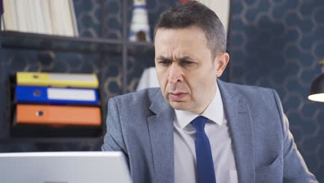 un hombre de negocios serio y enfocado lee las noticias en su portátil con interés y atención.