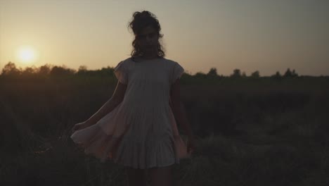 Toma-Panorámica-Manual-En-Cámara-Lenta-De-Una-Joven-Mujer-Bonita-Vestida-Con-Un-Vestido-Durante-Una-Hermosa-Puesta-De-Sol-En-La-Naturaleza