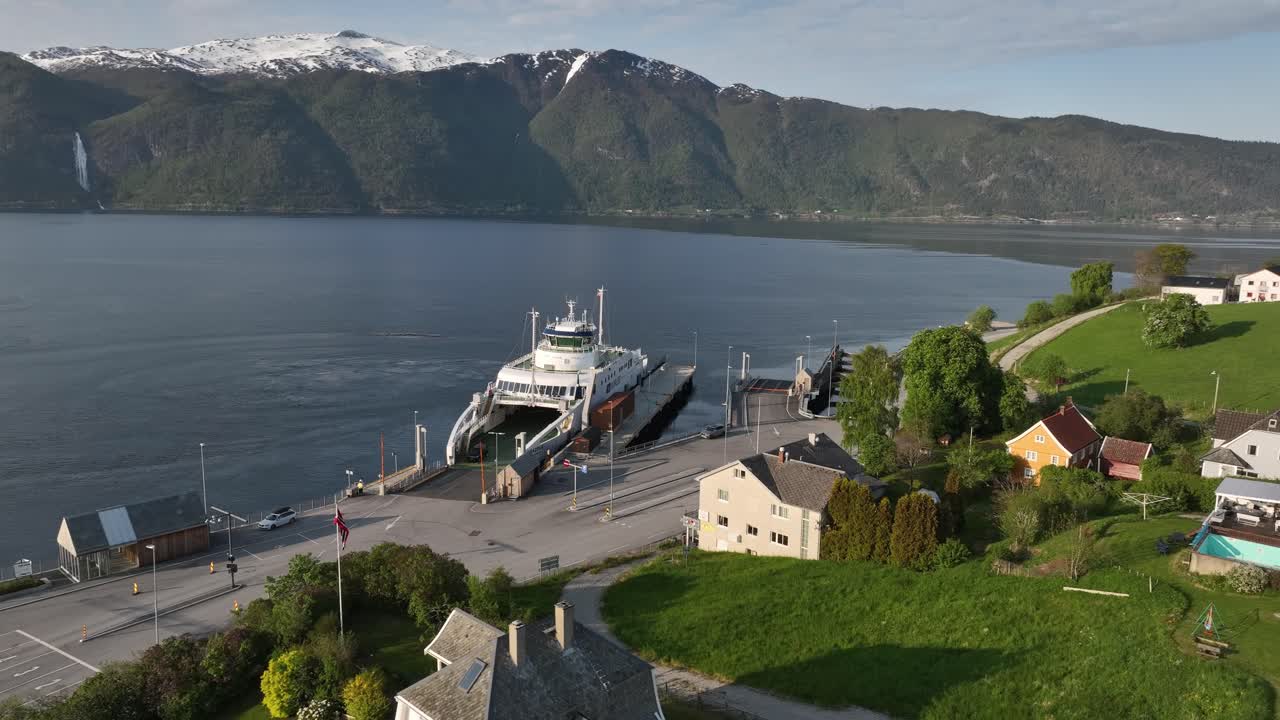 ferry eléctrico dragsvik junto a en vangsnes sognefjord noruega - aero con fiordo y paisaje de montaña en el fondo durante la puesta de sol de la noche