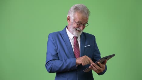 hombre de negocios barbudo y guapo contra un fondo verde.