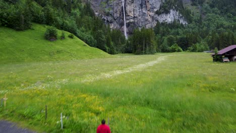 Aerial-:-Hiker-stand-on-a-gravel-road-admiring-almenbachfall-swiss-Scenery