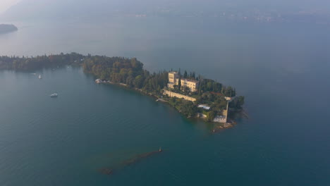 Tiro-Giratorio-Aéreo-Lento-Que-Revela-La-Majestuosa-Isola-Del-Garda-Y-Villa-Borghese-Cavazza