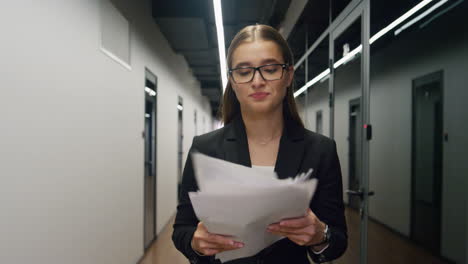 Stressed-manager-throwing-papers-in-glass-office.-Upset-woman-walking-hallway