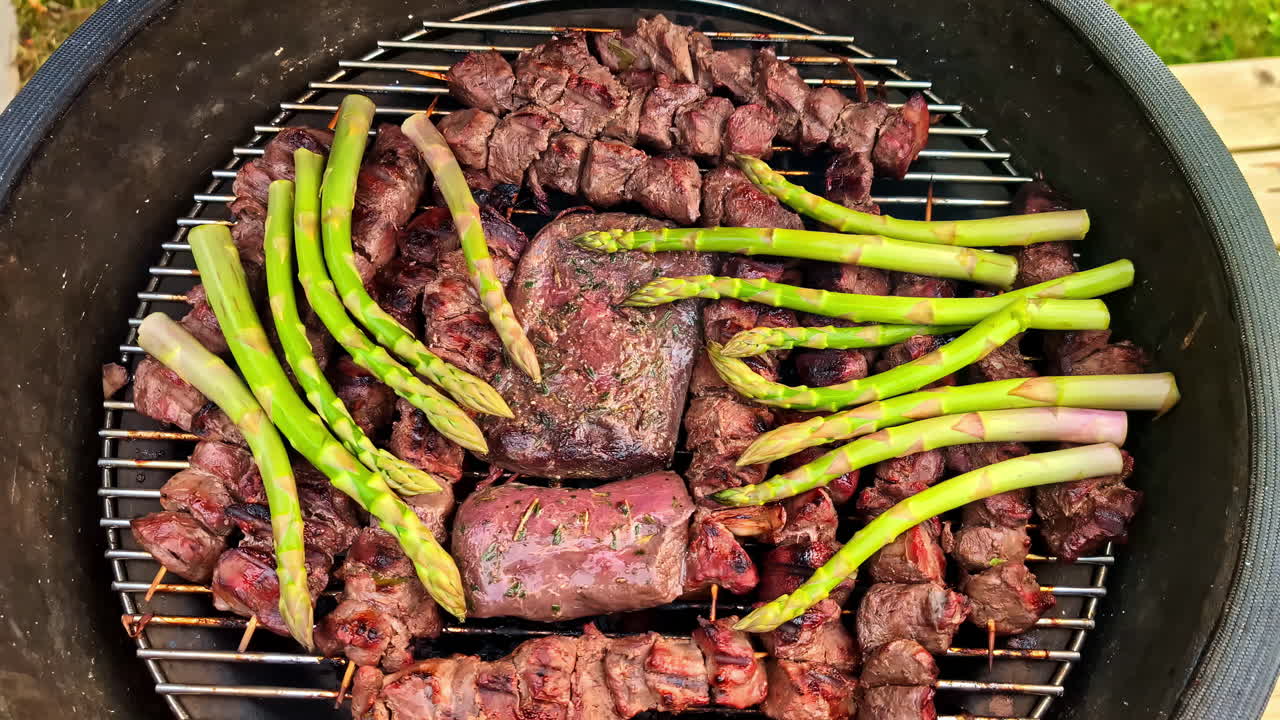 Grilling Steaks And Asparagus On The Griller. - high angle shot