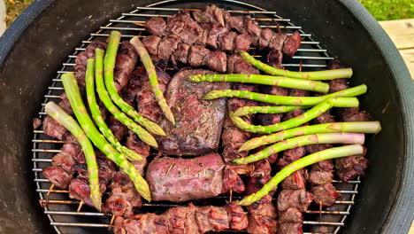 grilling steaks and asparagus on the griller. - high angle shot