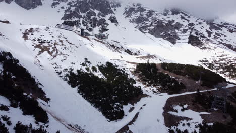 Vuelo-Aéreo-Sobre-Nordkette-Cubierto-De-Nieve,-Edificio-En-La-Cima-De-La-Montaña