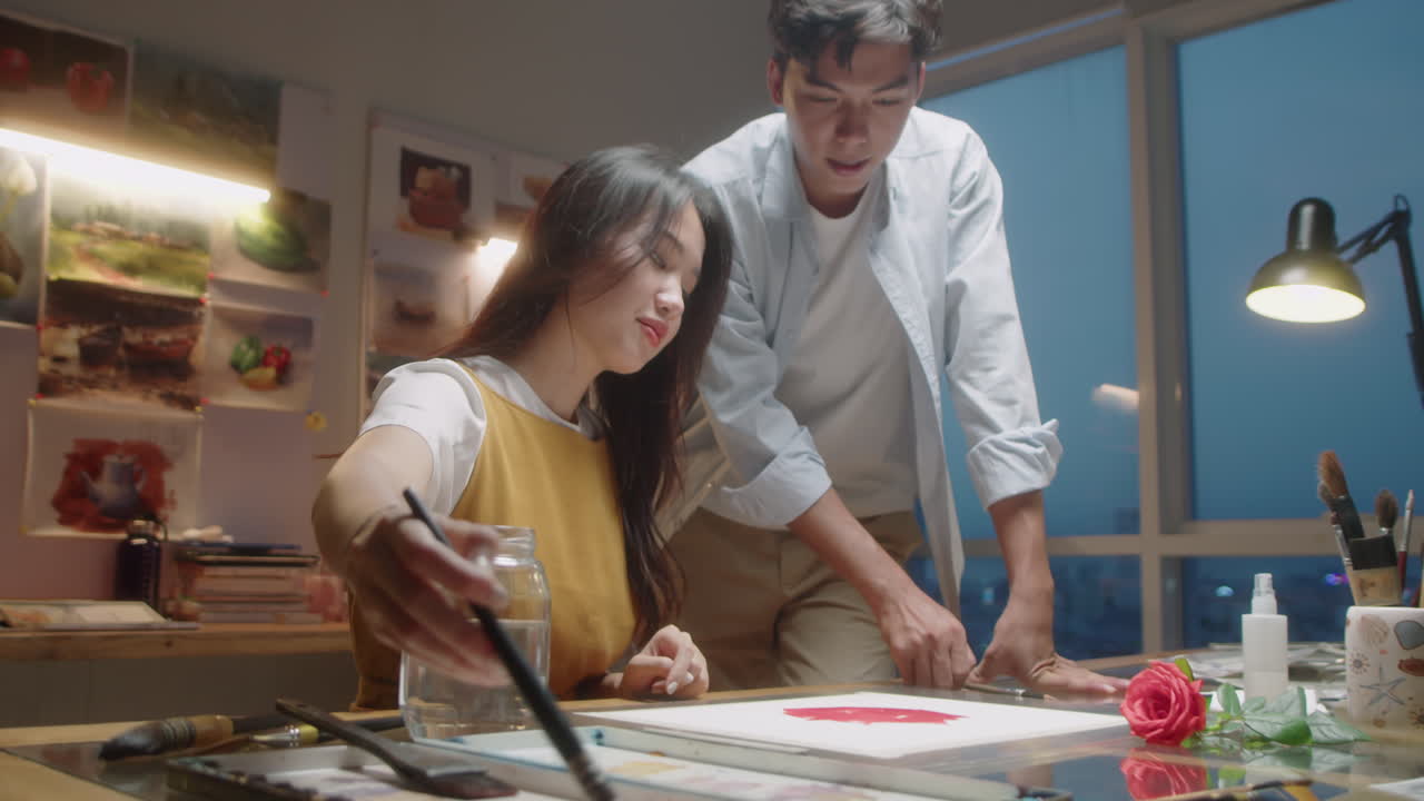 Asian Painter Giving Class to Female Student in Art School
