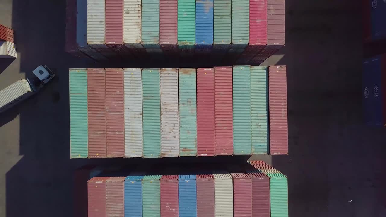 트럭과 화물 운반선이 수직으로 축소된 다채로운 선적 컨테이너