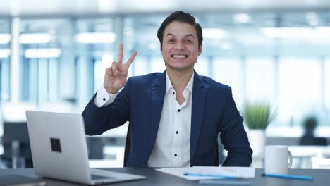 happy indian businessman showing victory sign