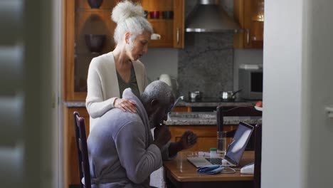 Sick-mixed-race-senior-couple-having-a-video-call-on-laptop-at-home