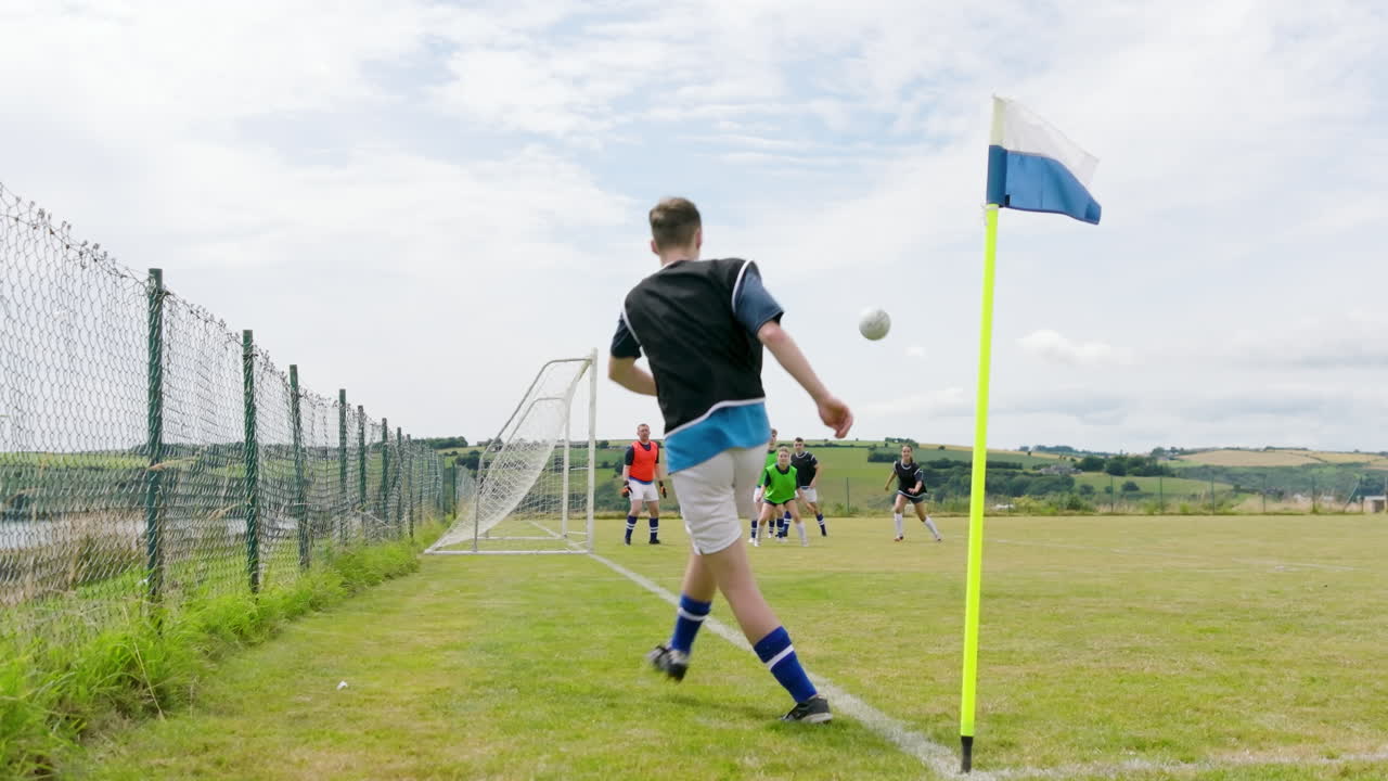 Male and female soccer players playing, passing ball from corner of pitch and running after ball