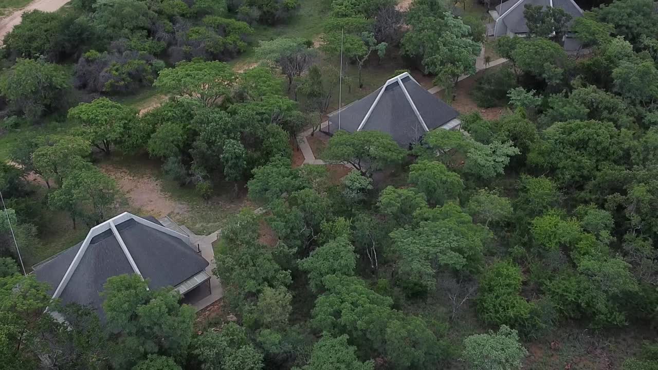 Aerial drone shot descending down on 3 luxury chalets situated in the heart of the African bushveld and part of an amazing close to nature safari experience, South Africa