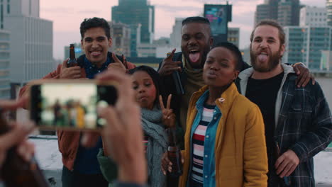 diverse group of friends posing for photo enjoying rooftop party celebration having fun drinking alcohol sharing weekend in city on social media