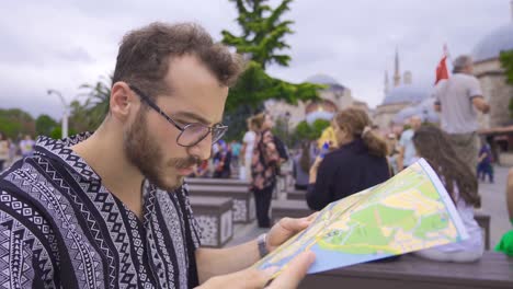 homme touristique regardant une carte papier.