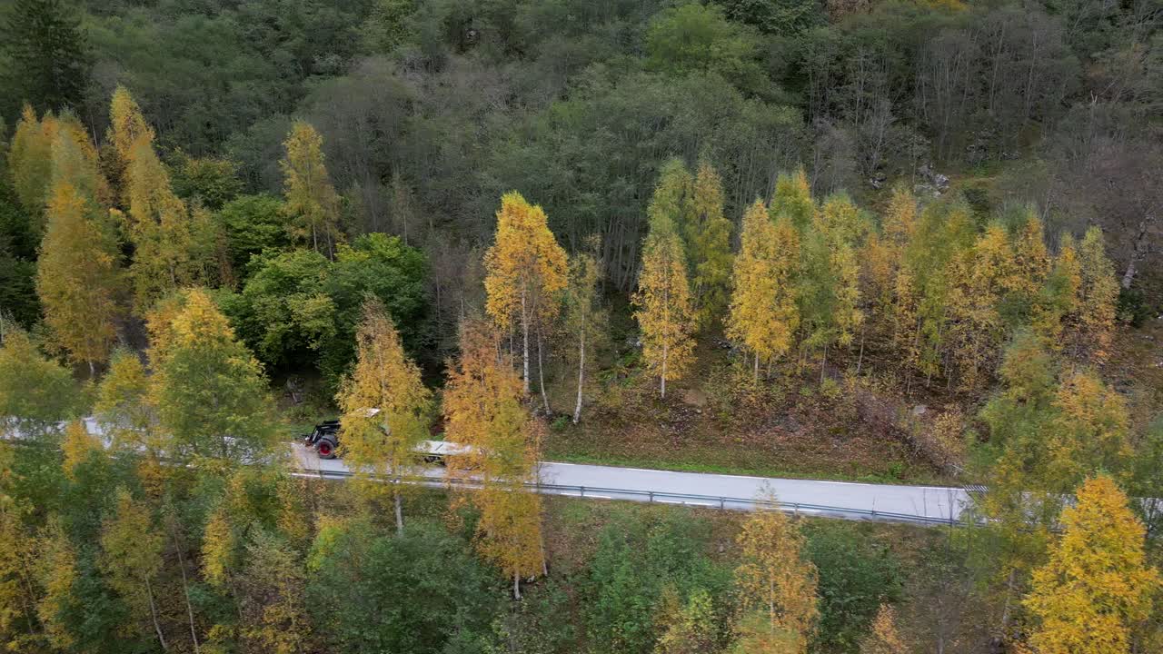 노르웨이 서부의 좁은 노르웨이 도로를 따라 트랙터가 운전합니다.