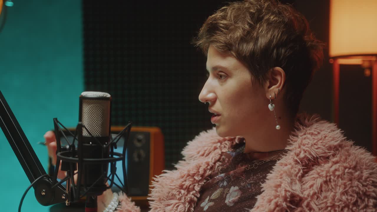 Female Podcaster Questioning Guest as Recording Interview in Studio