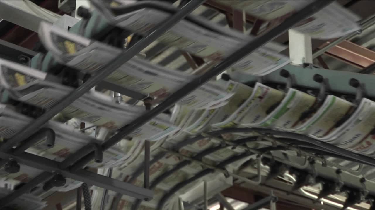 los periódicos fluyen a lo largo de una línea de montaje en una fábrica de periódicos 3