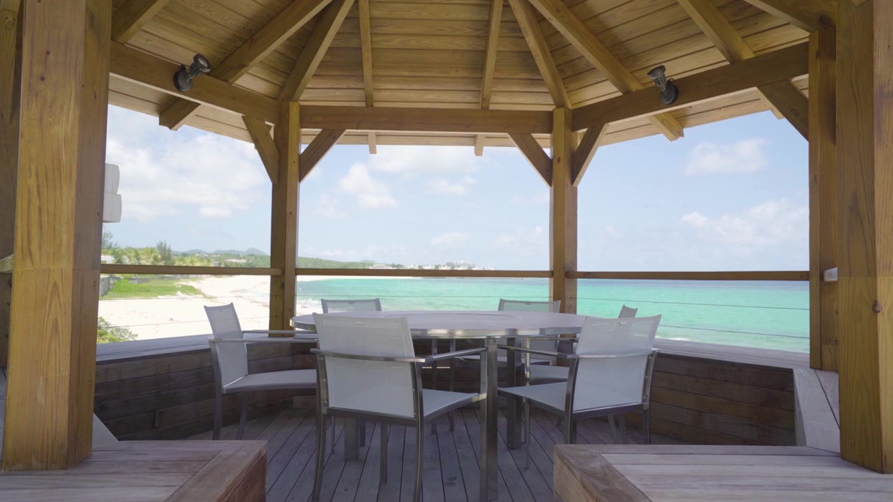 Pavillon med hvidt rundt bord og stol på en tropisk strand til møder, sammenkomster og konferencer