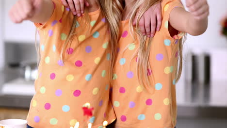 twin sisters with thumbs up at birthday party