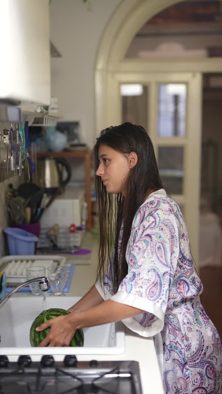 mujer lavando sandía en la cocina