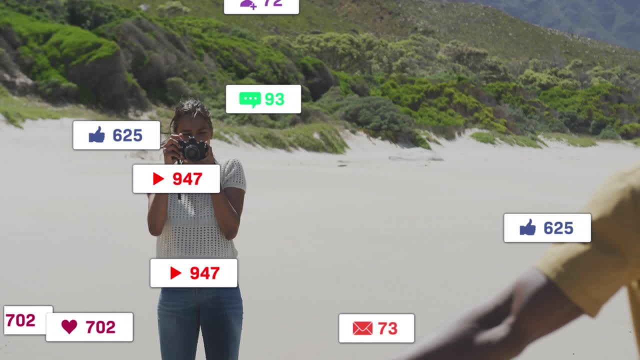 Woman holding DSLR camera on sandy beach, surrounded by floating social media marketing alerts