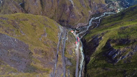 An-aerial-shot-of-a-train-going-around-the-"Nariz-del-Diablo"-or-Devil's-Nose-in-Alausí,-Chimborazo-Province,-Ecuador