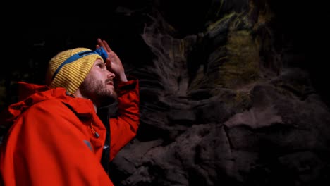 male hiker exploring a dark cave 4k