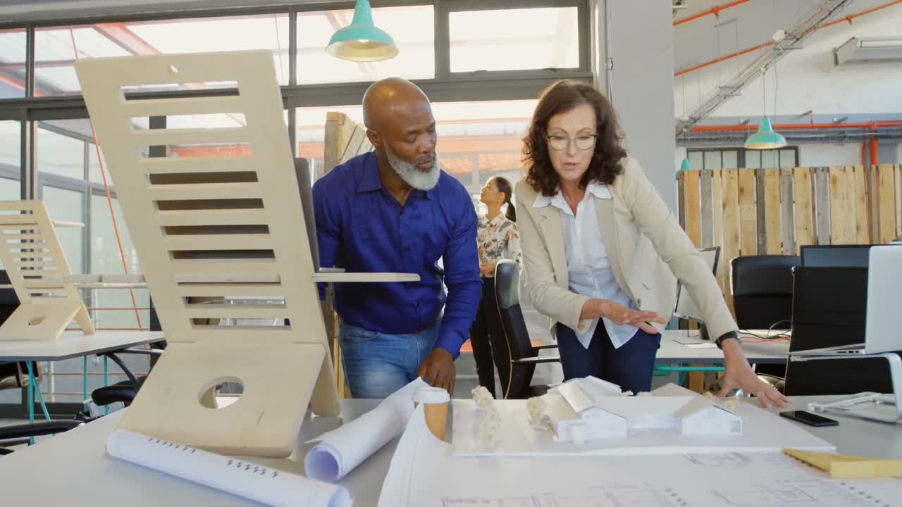 Business executives discussing over architectural model 4k