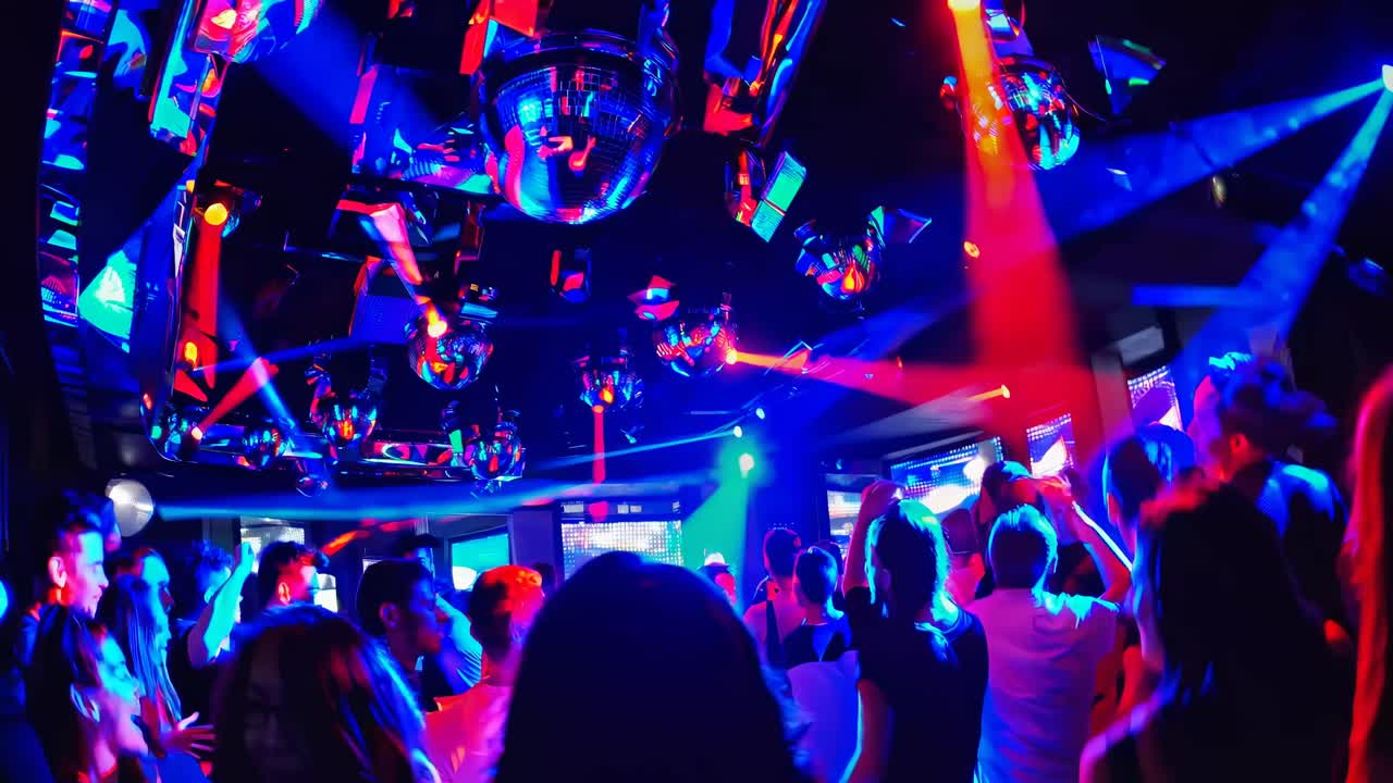 Cena vibrante em uma boate com luzes coloridas e multidão dançando, capturada de um ângulo baixo