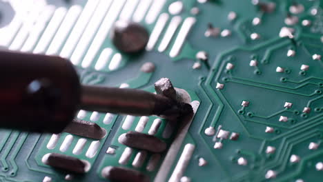 the engineer replaced the ic transistor with a soldering iron on the electrical circuit pcb board to fix device device