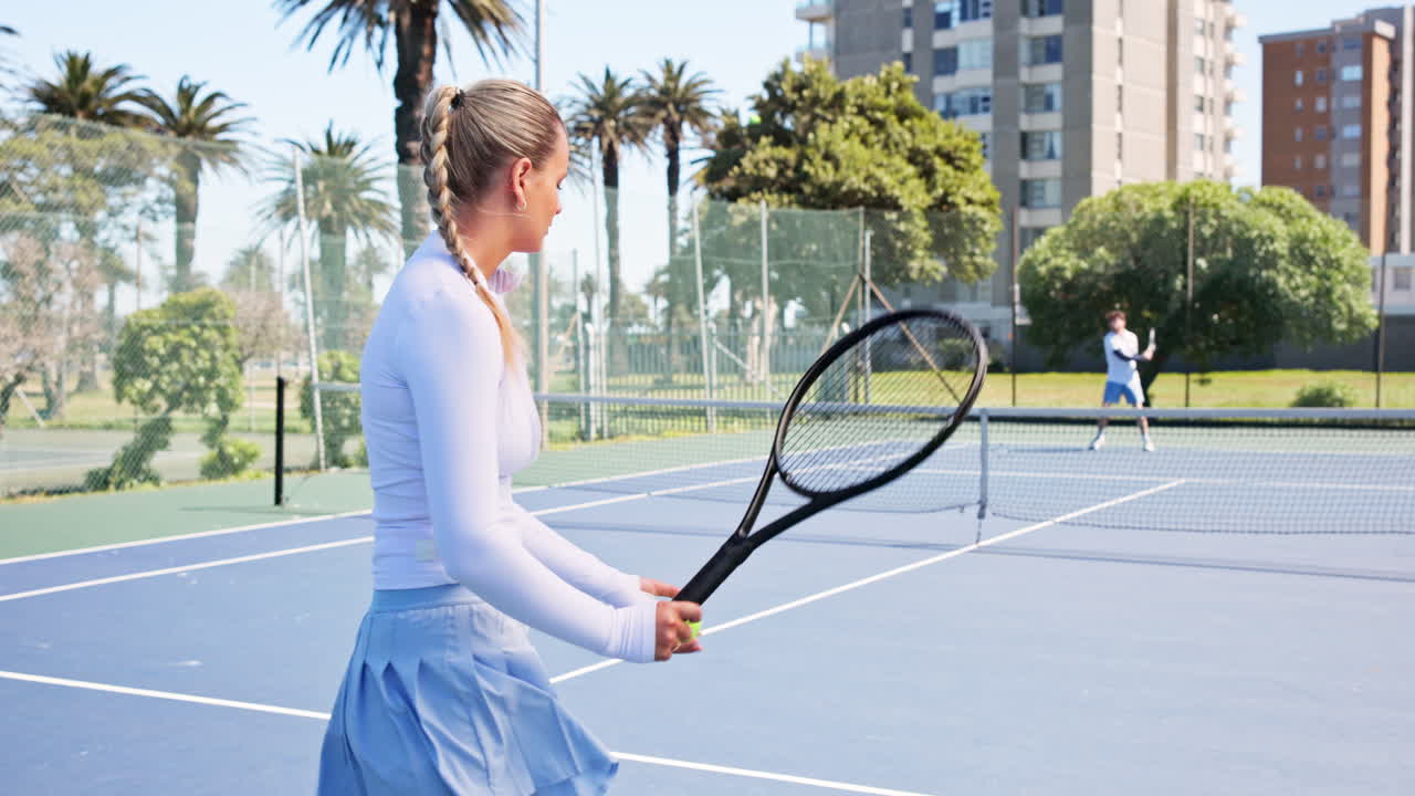Kvinnelig tennisspiller serverer på en solrik utendørsbane