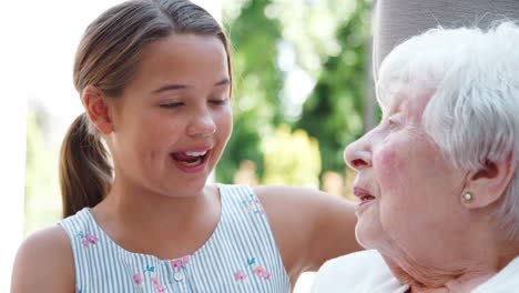 Granddaughter-Sitting-And-Talking-With-Grandmother-During-Visit-To-Retirement-Home