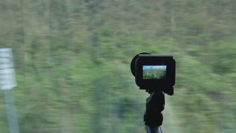 cámara de acción a través de la ventana filmando un viaje en tren