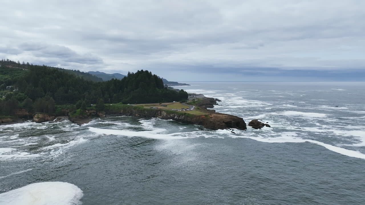 Aerial view approaching the Boiler Bay State Scenic Viewpoint, in cloudy Oregon