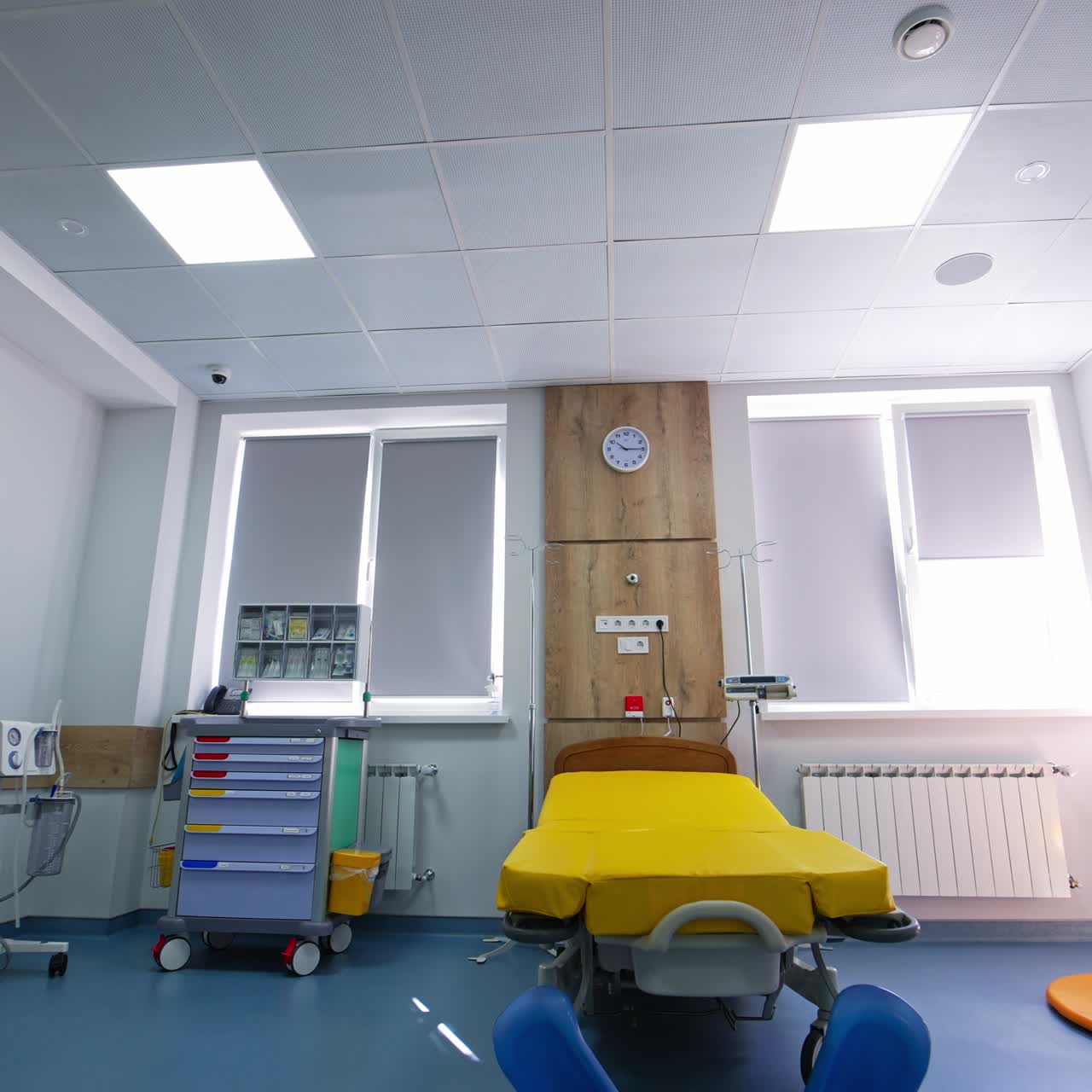 Empty wheeled bed for women in labor. Big light delivery ward in up-to-date maternity clinic. View from below
