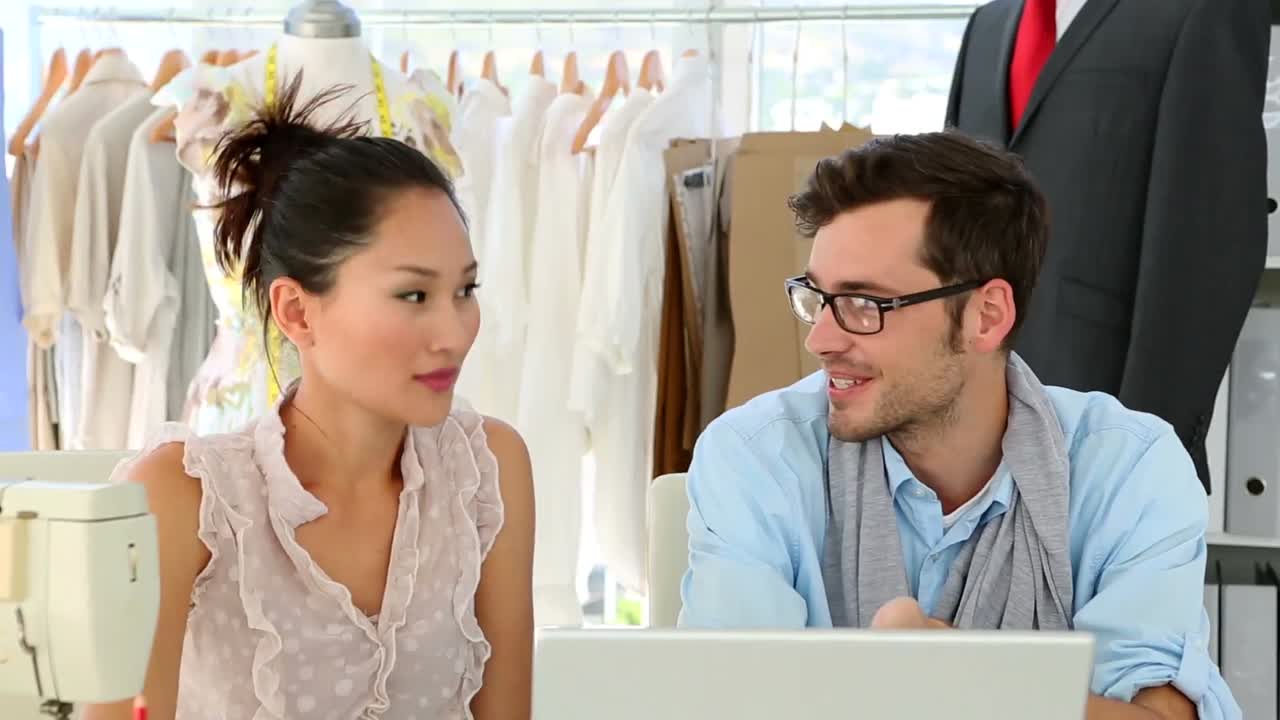 equipo de diseño trabajando juntos en un portátil