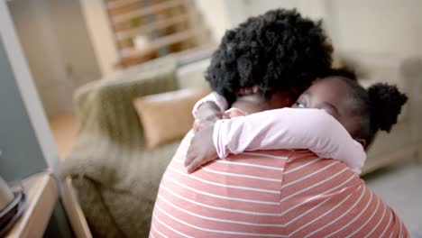 african american mother and daughter hugging at home, slow motion