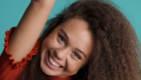 caucasian curly haired woman smiling to the camera.