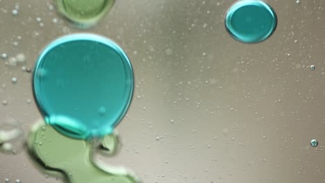 close-up of blue and green liquid with floating bubbles and blobs in motion inside a lava lamp, viewed in a horizontal orientation. hypnotic and abstract visual texture