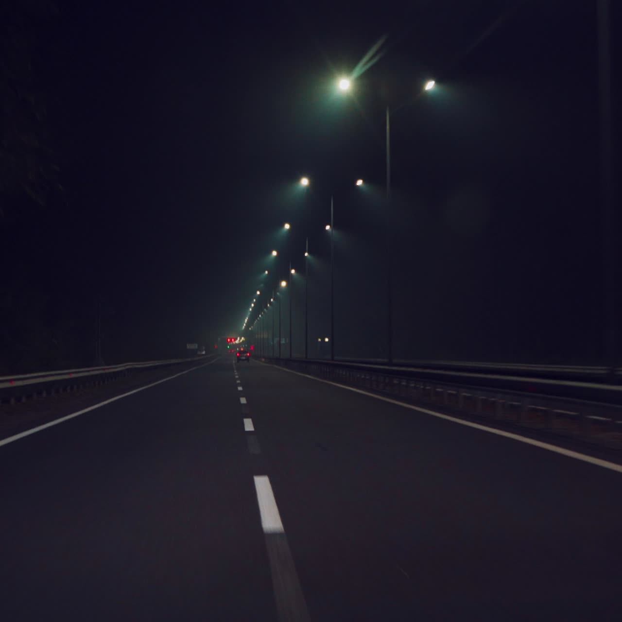 Un'auto sta guidando velocemente lungo l'autostrada al buio. Viaggio notturno in auto. Velocità di movimento.