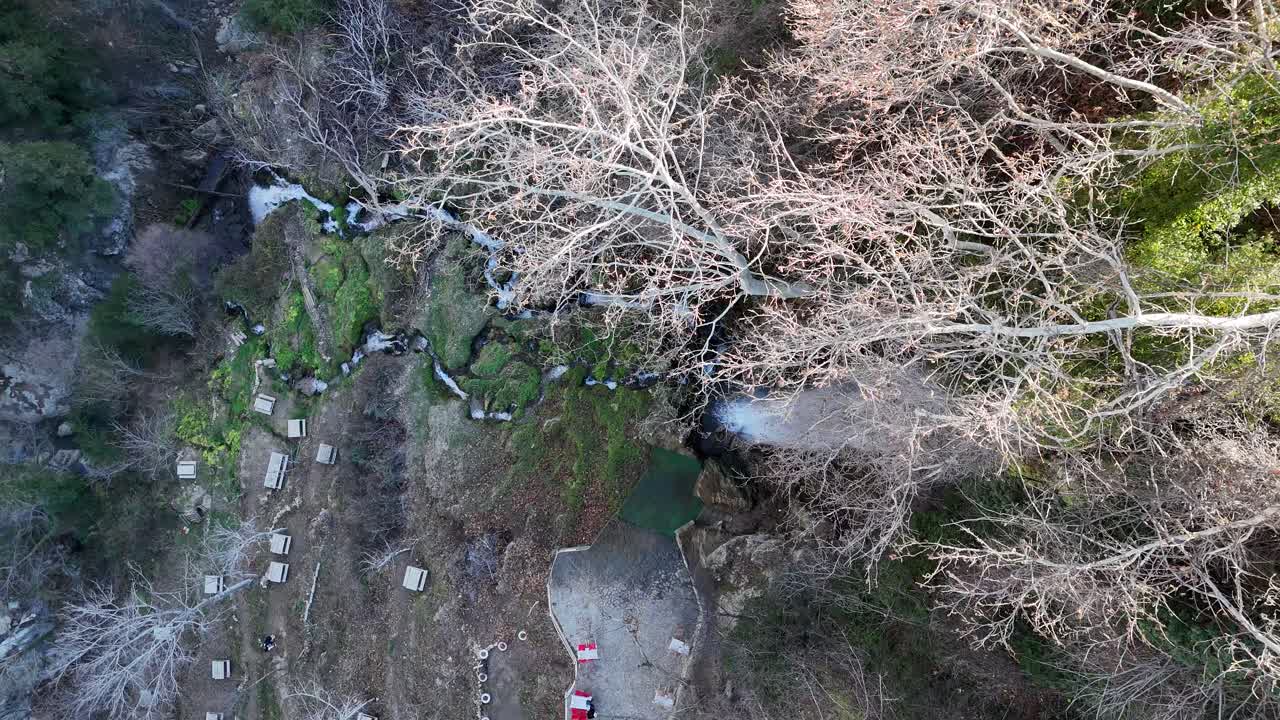 imágenes de drones del agua que fluye a través de las piedras marrones, vista de cascadas naturales en tierras inclinadas
