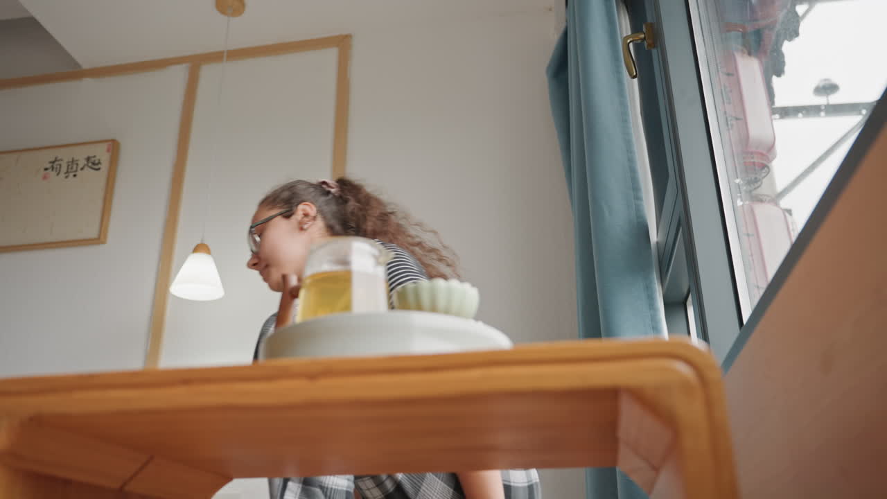 Scena d'hotel pacifica. Ambiente alberghiero tranquillo con ospite riflessivo. Contesto sereno che mostra un visitatore sognante accanto alla finestra. Atmosfera pacifica in hotel con un ospite assorto nei pensieri vicino alla finestra.