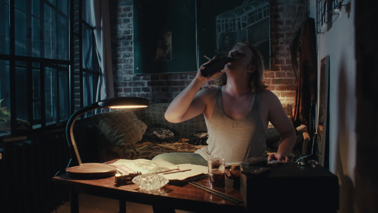 Man Smoking and Drinking in a Dim Apartment