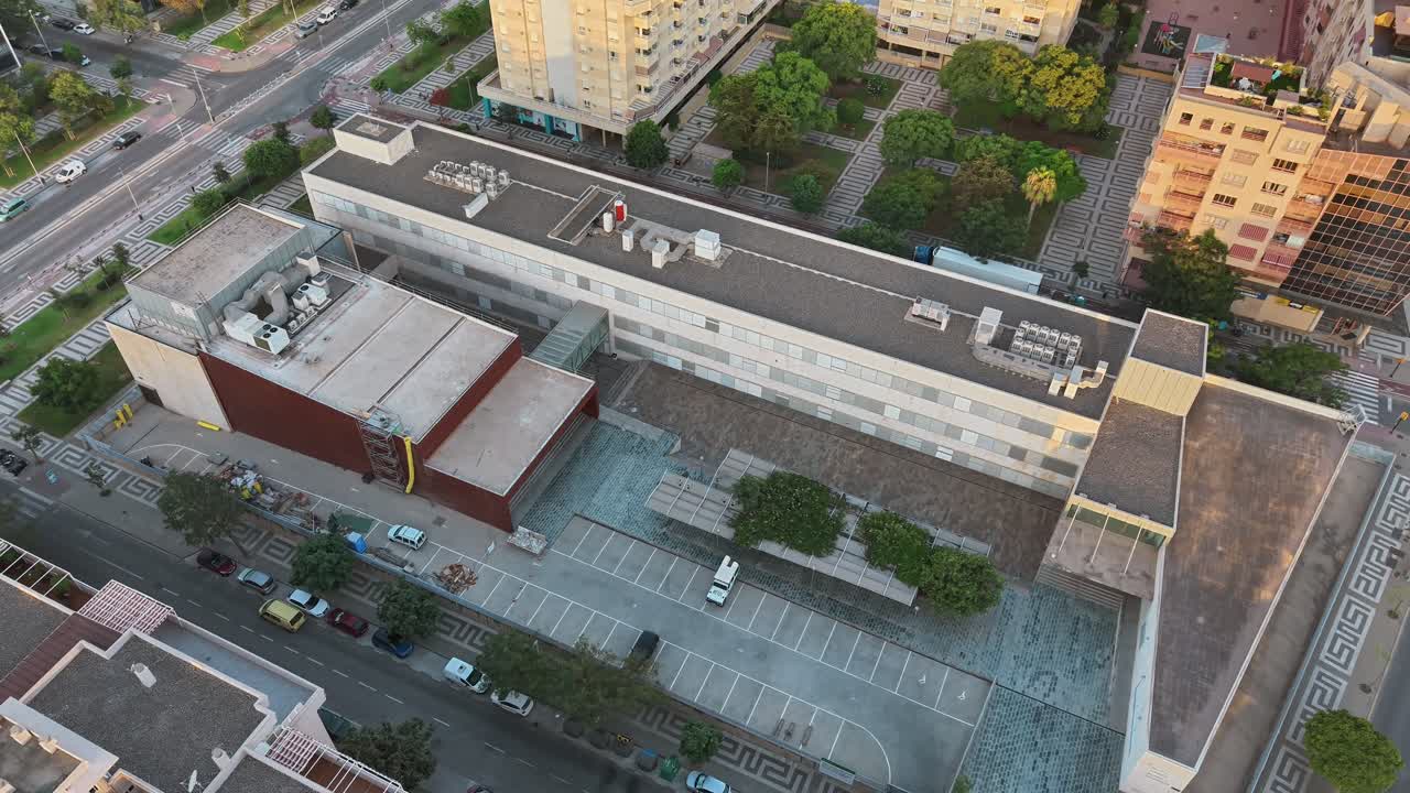 Top-down spiral aerial movement over Málaga School of Dramatic Arts aka Escuela Superior de Arte Dramático de Málaga rooftop, Málaga, Spain