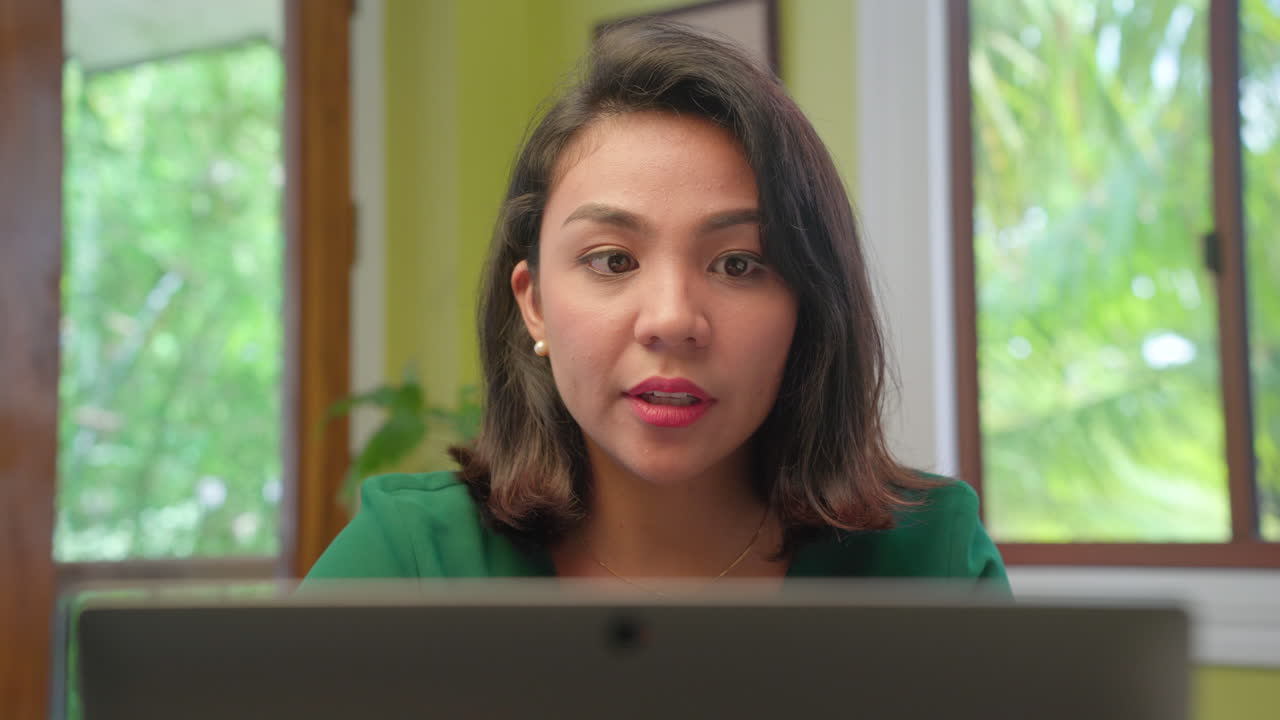 Young Short Hair Asian Woman Talking and Working on Computer Laptop at Home, Close-up Shot