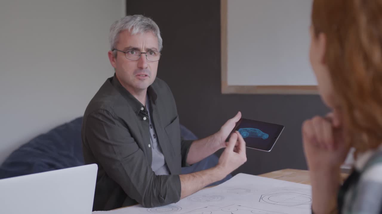 hombre caucásico y una mujer trabajando en una oficina creativa