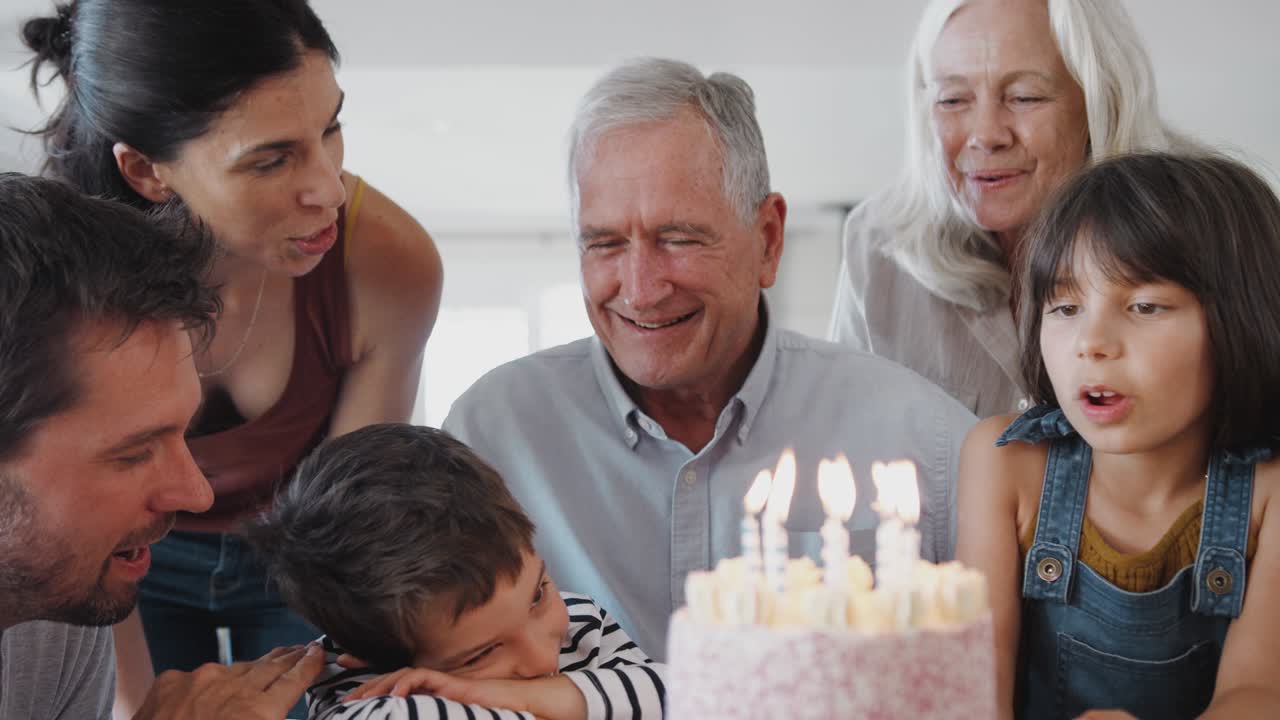 다세대 가족 이 집 에서 할아버지 와 함께 생일을 축하 하고  ⁇ 불 을 꺼내고 있다