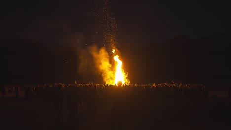 bonfire in front of large crowd of people at night, tribal gathering, paganism, spirituality, full moon rainbow gathering