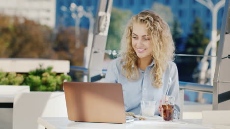 Joven-Mujer-De-Negocios-Trabajando-En-Un-Café-Con-Una-Computadora-Portátil-Comer-Helado-En-La-Terraza-De-Verano-De-Un-Café