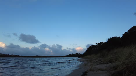 Man-walking-down-a-beach-on-a-cold-winters-morning-in-Tasmania,-Australia